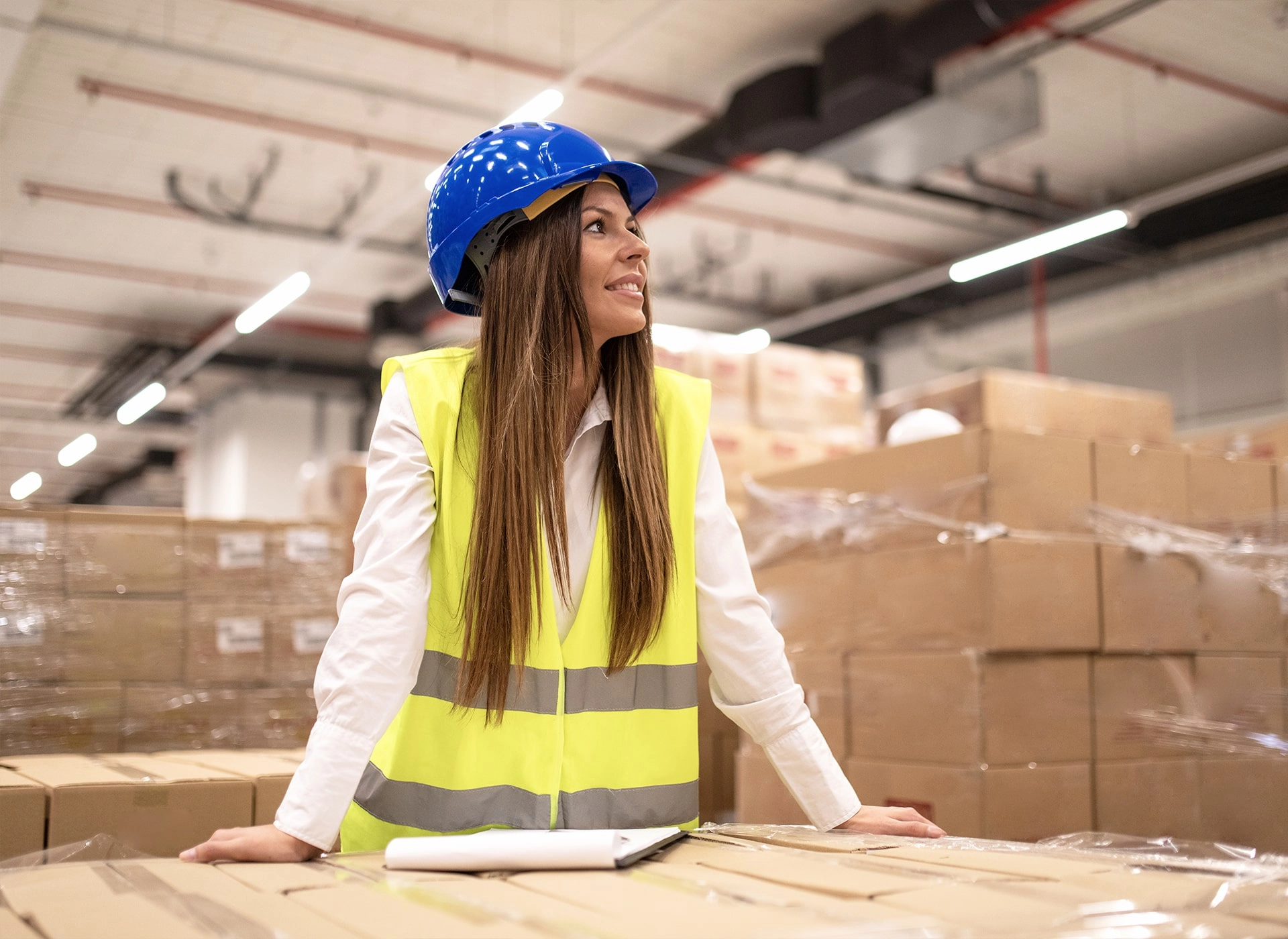 Arbeiterin im Lagerraum mit Schutzhelm